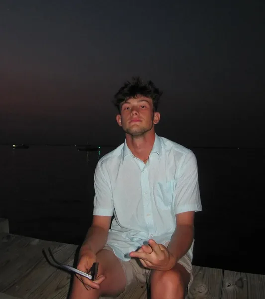 Chase sitting on a dock at night